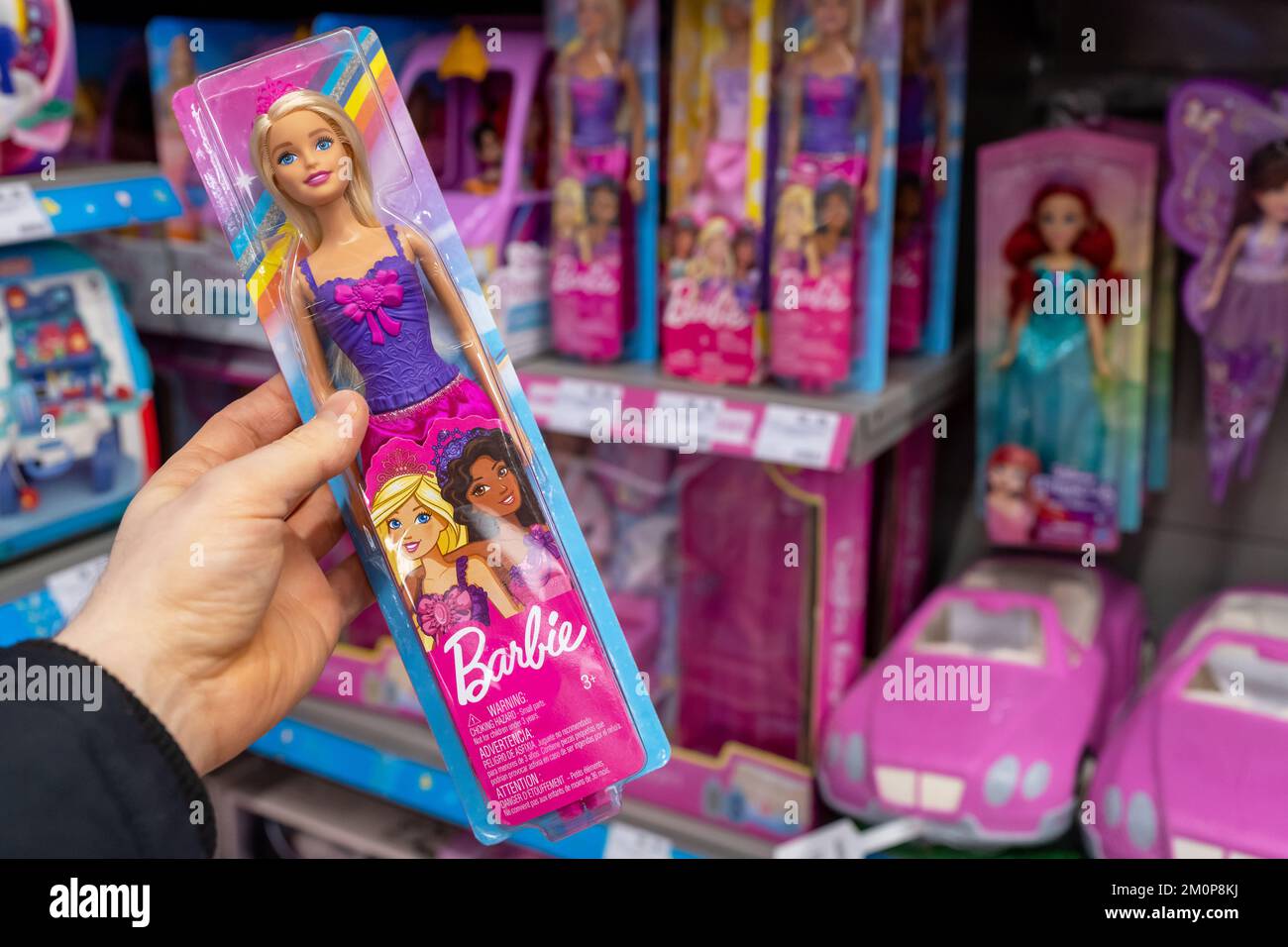 Barbie nella mano di un cliente in un negozio di giocattoli. Barbie è una bambola di moda prodotta dalla ditta americana Mattel, Inc Foto Stock