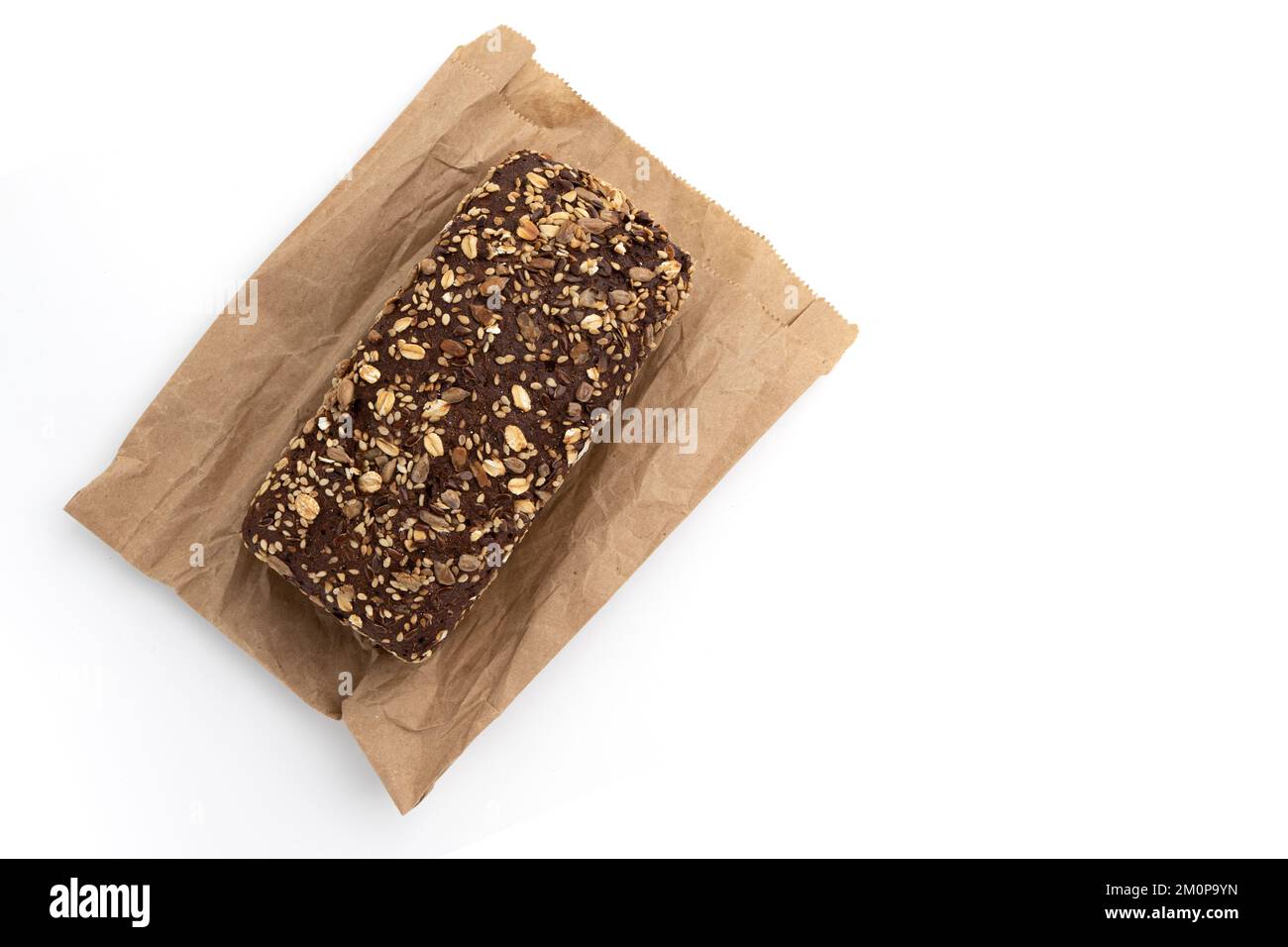 pane di segale mattone su carta da imballaggio isolato su fondo bianco, cottura fatta in casa, grano intero fresco Foto Stock
