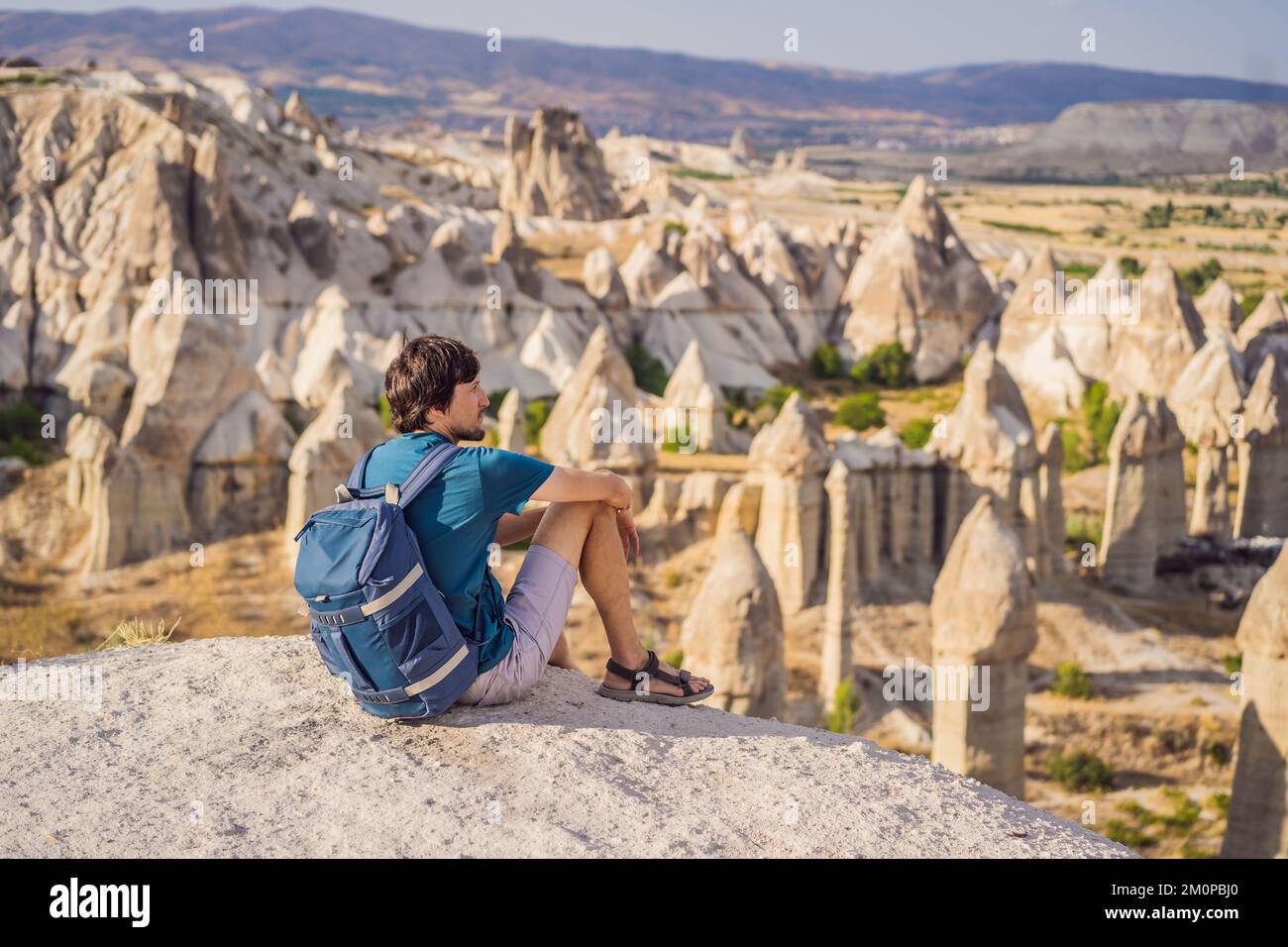 Giovane esploratore valle con formazioni rocciose e grotte delle fate vicino a Goreme in Cappadocia Turchia Foto Stock