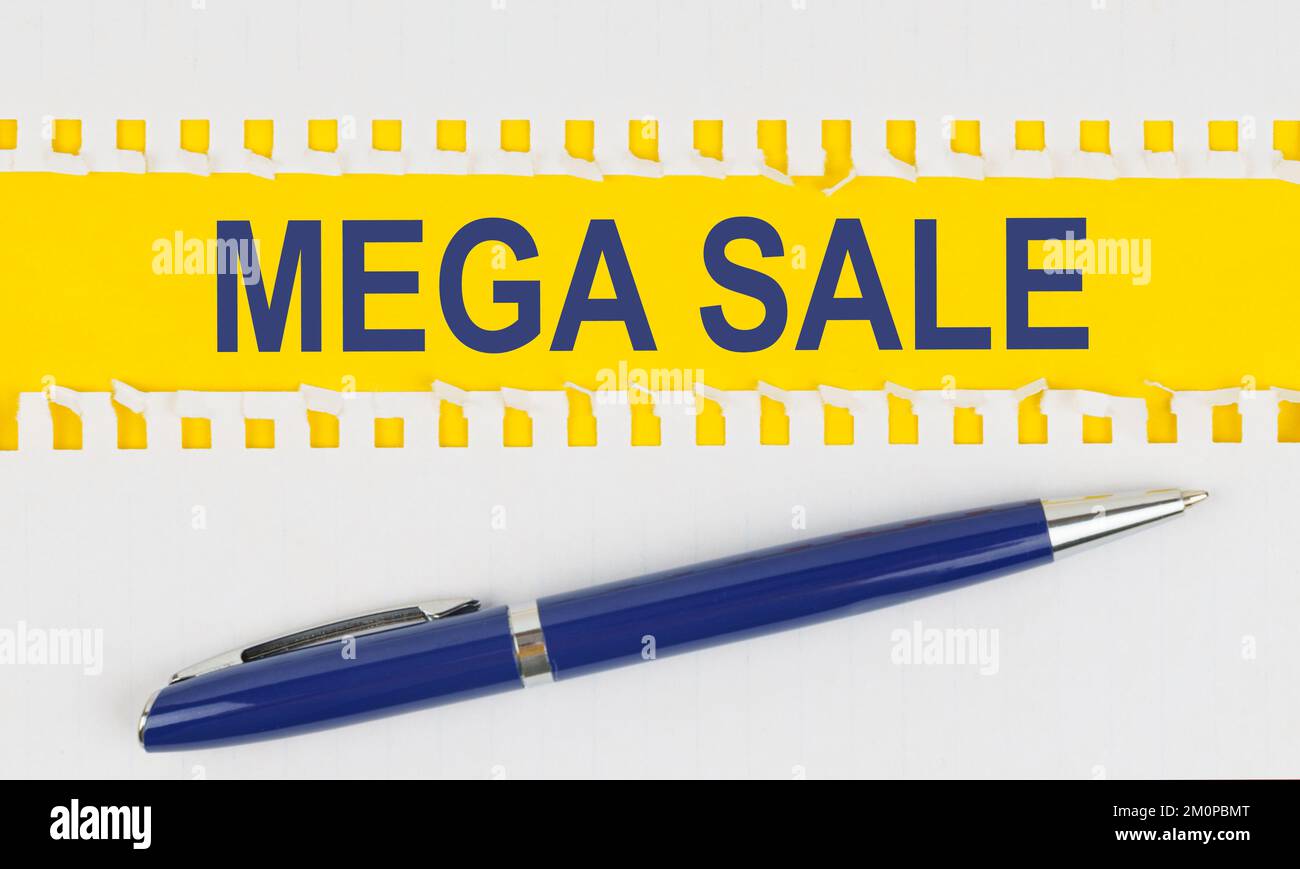 Affari e finanza. Sul tavolo sono riportati due fogli di un quaderno e una penna su sfondo giallo scritta - MEGA SALE Foto Stock