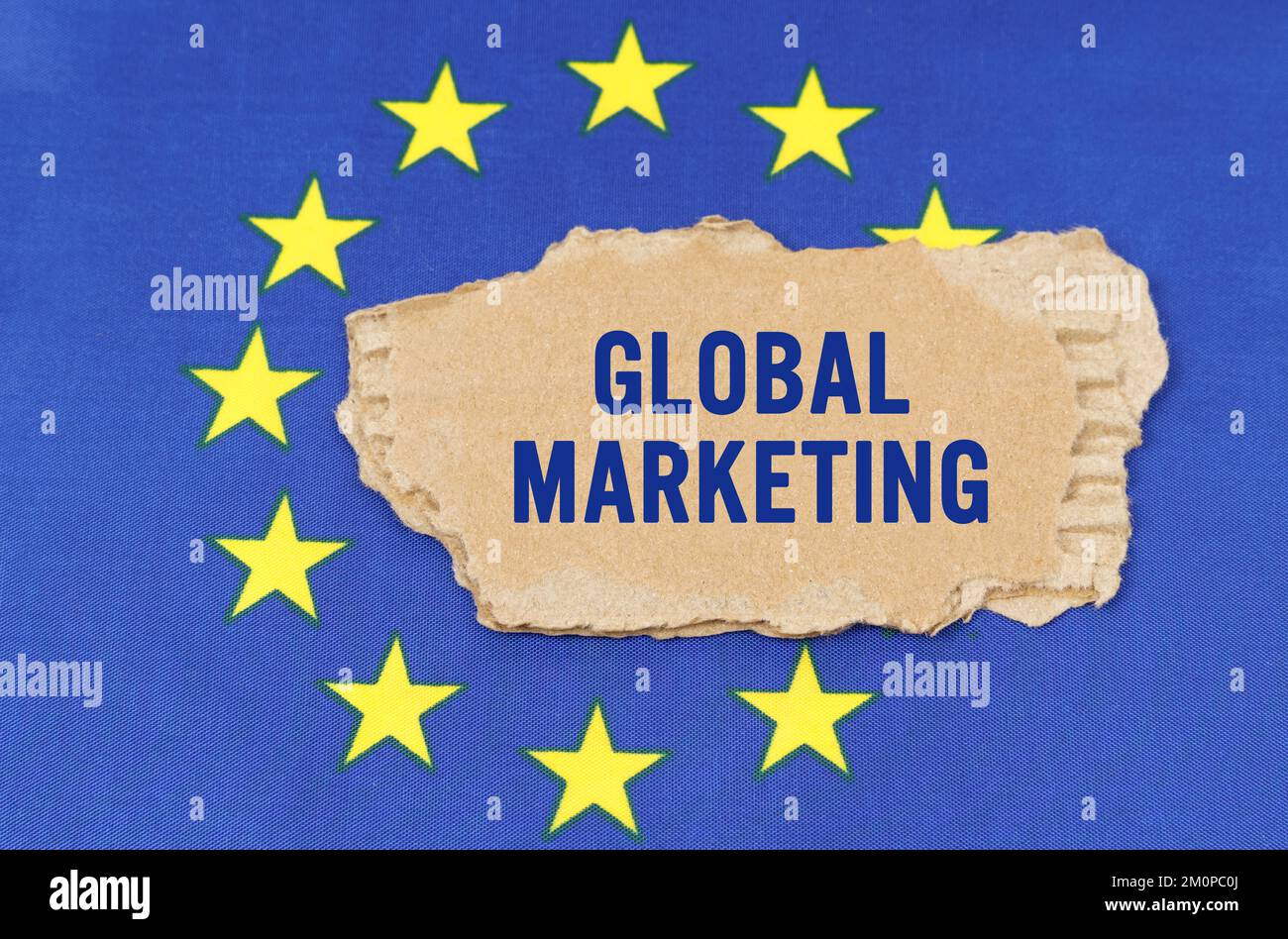 Concetto di business e finanza. C'è una scatola di cartone sulla bandiera dell'UE che dice- MARKETING GLOBALE Foto Stock