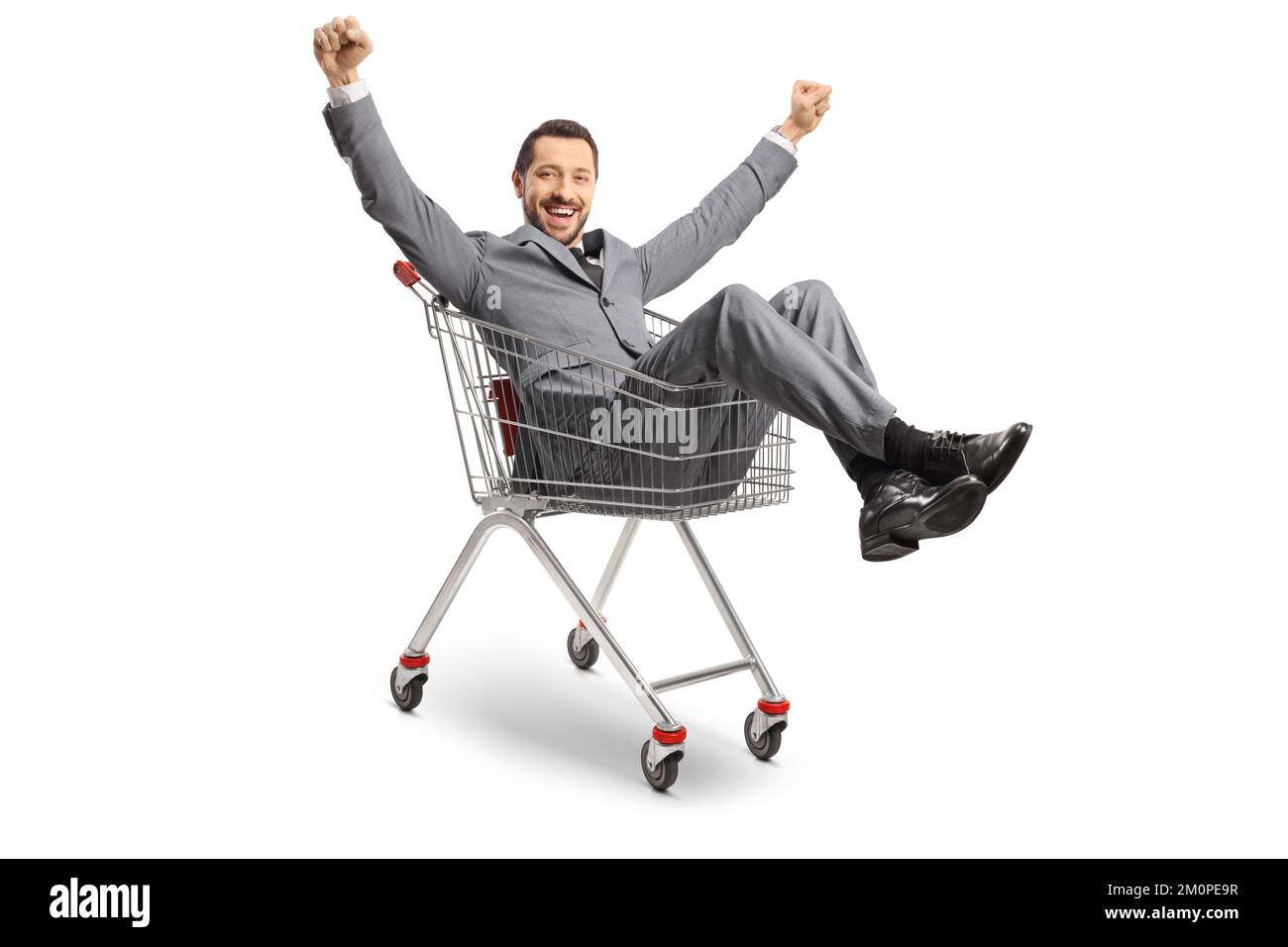 Uomo d'affari seduto all'interno di un carrello della spesa e gesturing felicità isolato su sfondo bianco Foto Stock