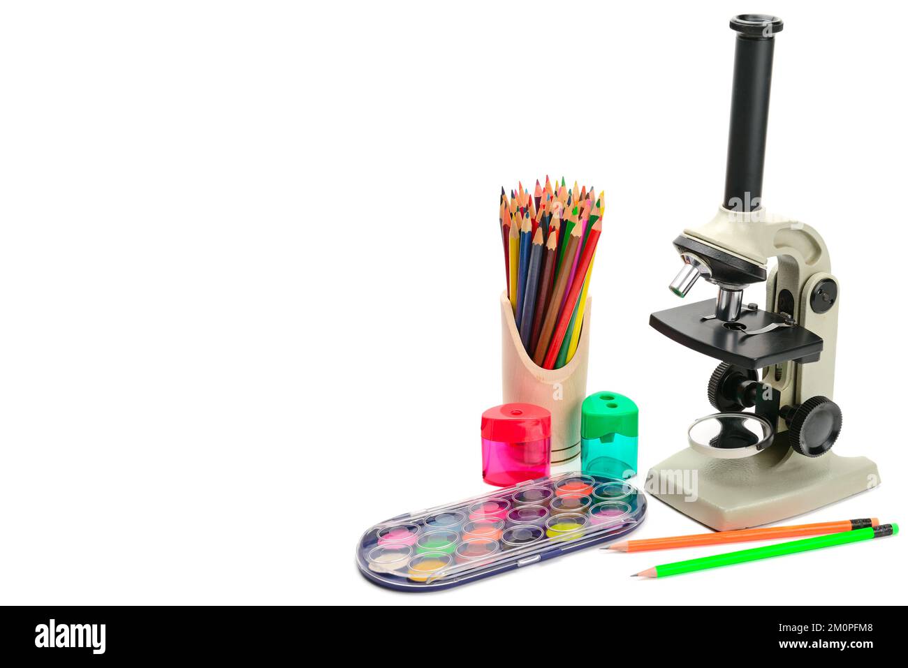 Microscopio da laboratorio e altri materiali scolastici isolati su sfondo bianco. Spazio libero per il testo. Foto Stock