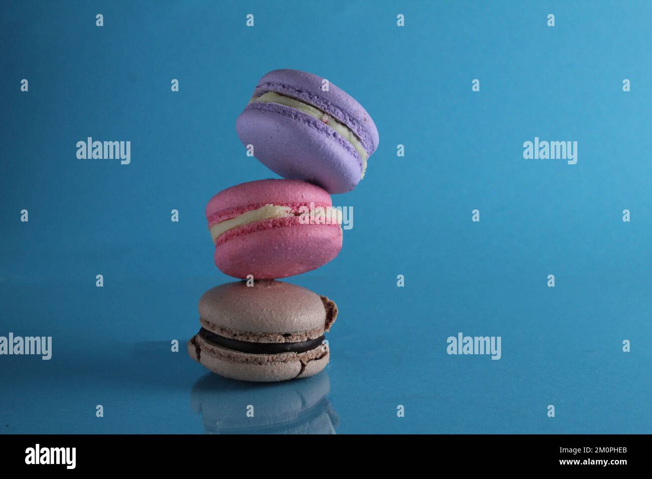 volo in volo macaroon alimentare levitating su uno sfondo blu con spazio per il testo Foto Stock