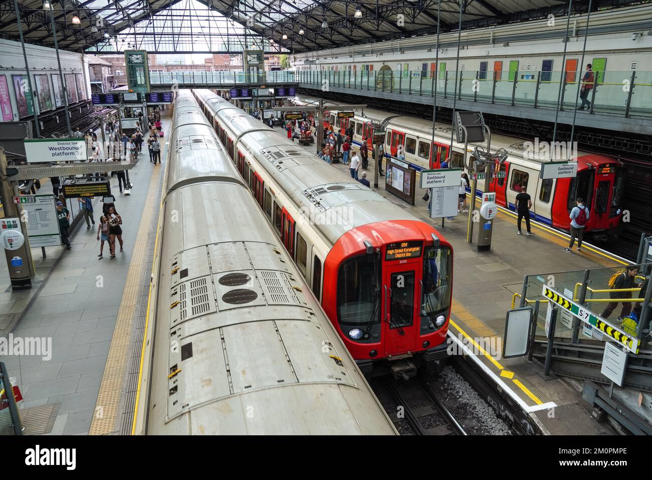 Passeggeri sul binario della metropolitana di Earl's Court, stazione della metropolitana Londra Inghilterra Regno Unito Regno Unito Foto Stock