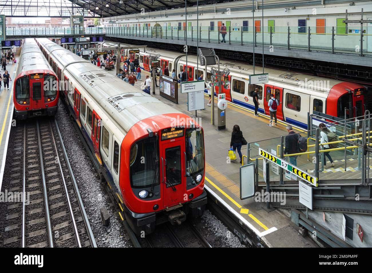 Passeggeri sul binario della metropolitana di Earl's Court, stazione della metropolitana Londra Inghilterra Regno Unito Regno Unito Foto Stock