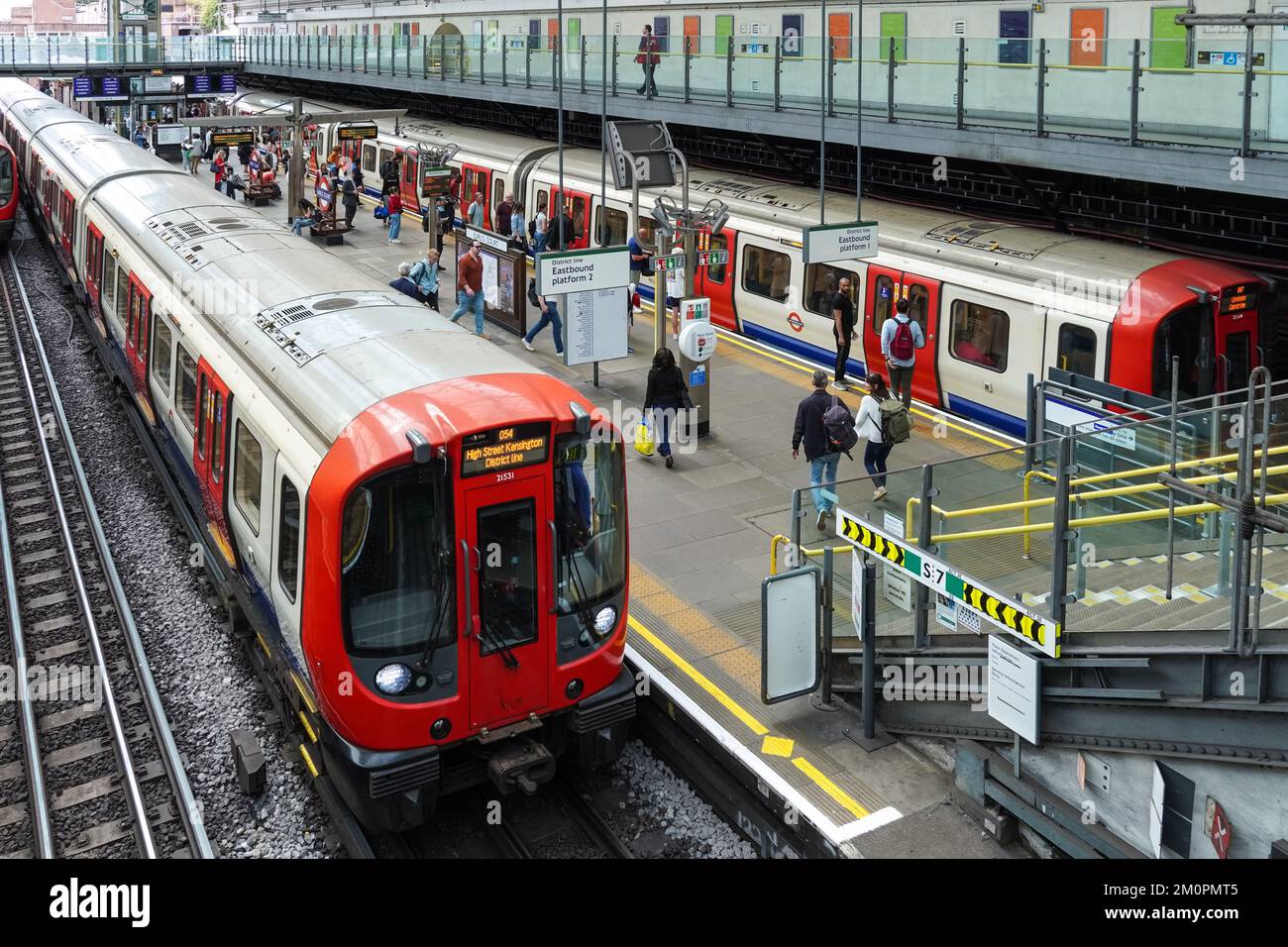 Passeggeri sul binario della metropolitana di Earl's Court, stazione della metropolitana Londra Inghilterra Regno Unito Regno Unito Foto Stock