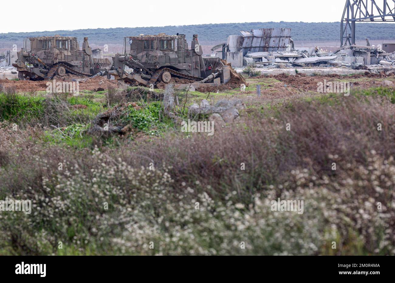 Gaza, Palestina. 07th Dec, 2022. Un carro armato israeliano di Merkava è disposto vicino agli escavatori e ai bulldozer israeliani che demoliscono i resti del passaggio commerciale di Karni vicino al confine di Gaza, mentre Israele ha deciso di estendere una barriera di sicurezza nella posizione del terminale a lungo defunto. Credit: SOPA Images Limited/Alamy Live News Foto Stock