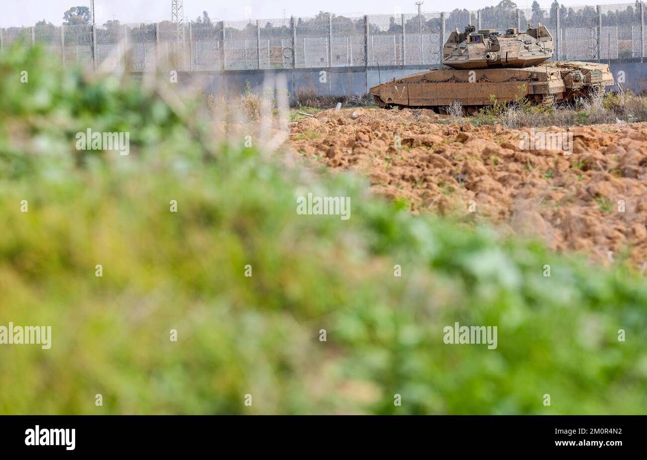 Gaza, Palestina. 07th Dec, 2022. Un carro armato israeliano di Merkava è disposto vicino agli escavatori e ai bulldozer israeliani che demoliscono i resti del passaggio commerciale di Karni vicino al confine di Gaza, mentre Israele ha deciso di estendere una barriera di sicurezza nella posizione del terminale a lungo defunto. Credit: SOPA Images Limited/Alamy Live News Foto Stock