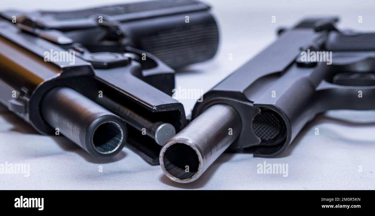 Due pistole nere di calibro 40 e 45, con slide aperte su fondo bianco Foto Stock