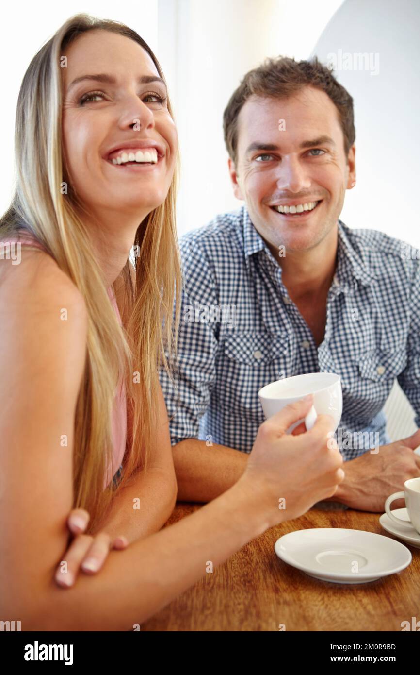 Condividere una risata su una tazza di caffè. Una giovane coppia attraente che si gode una tazza di caffè nel ristorante. Foto Stock