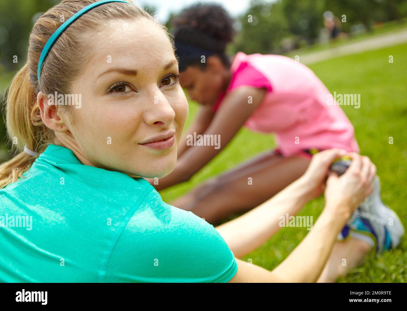 Riscaldamento per il nostro jogging. un'atleta femminile che guarda sopra la spalla mentre si allunga. Foto Stock