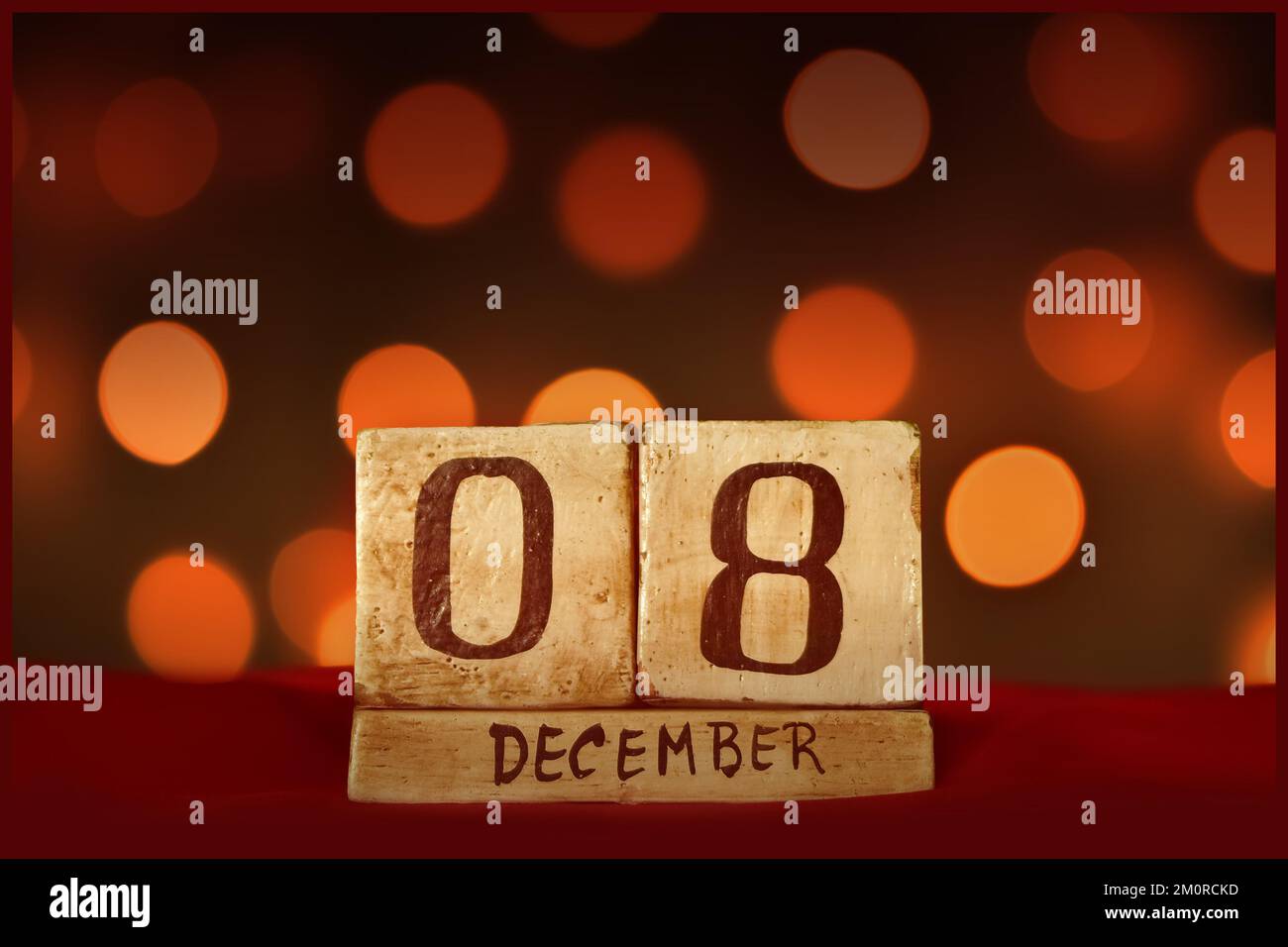 Dicembre 8 calendario in legno blocco vintage su tessuto rosso, festive bokeh luci sfondo biglietto di auguri per celebrare le vacanze, compleanno, salvare la data fo Foto Stock