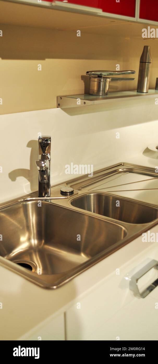 Interno di lussuosa cucina moderna e lavandino, rubinetto e scarico in acciaio inossidabile Foto Stock