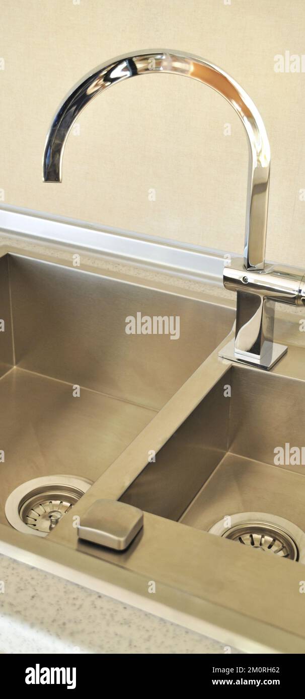 Interno di lussuosa cucina moderna e lavandino, rubinetto e scarico in acciaio inossidabile Foto Stock