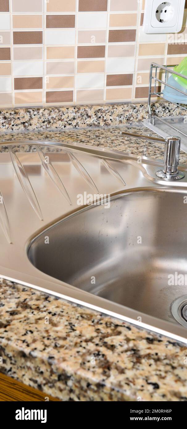 Interno di lussuosa cucina moderna e lavandino, rubinetto e scarico in acciaio inossidabile Foto Stock