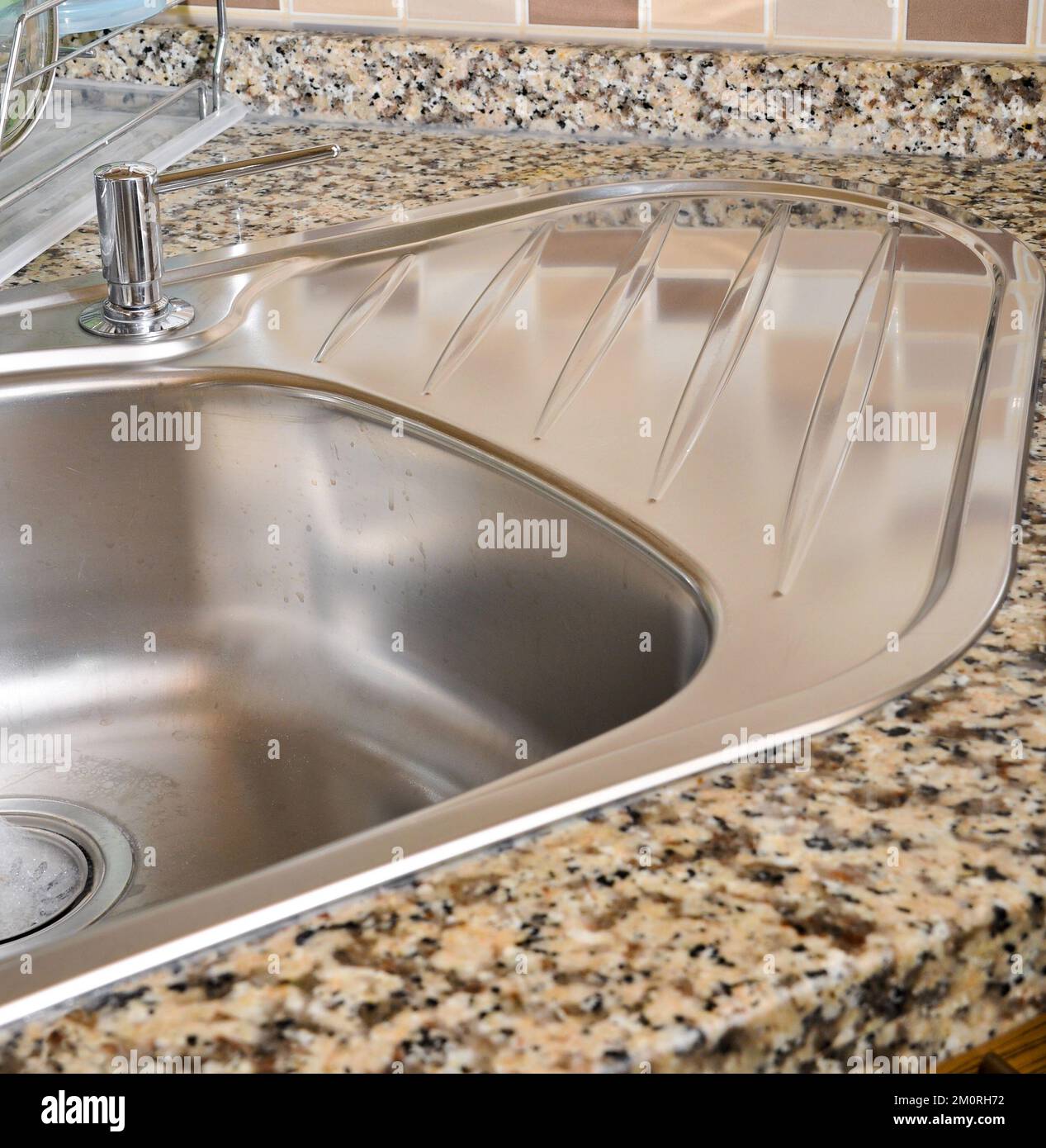 Interno di lussuosa cucina moderna e lavandino, rubinetto e scarico in acciaio inossidabile Foto Stock