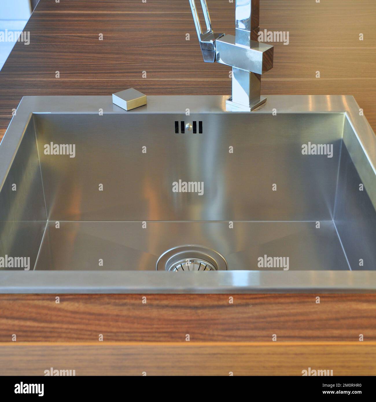 Interno di lussuosa cucina moderna e lavandino, rubinetto e scarico in acciaio inossidabile Foto Stock