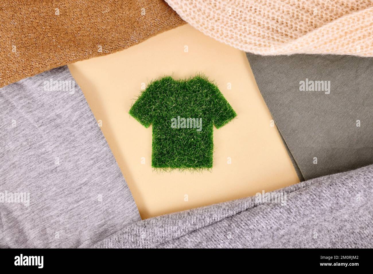 Concetto di abbigliamento ecologico con camicia in erba circondata da maglioni Foto Stock