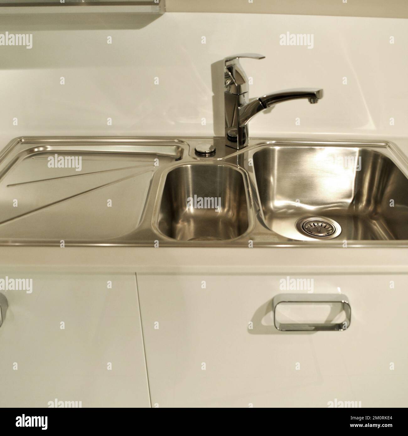 Interno di lussuosa cucina moderna e lavandino, rubinetto e scarico in acciaio inossidabile Foto Stock