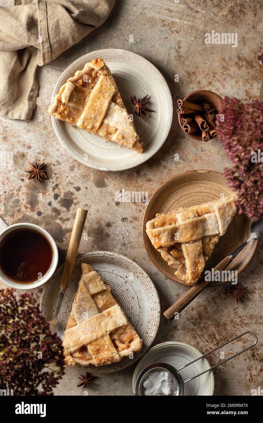 Tre piatti con una fetta di deliziosa torta di mele fatta in casa, vista dall'alto tavolo scena su sfondo marrone textured. Giacitura piatta Foto Stock