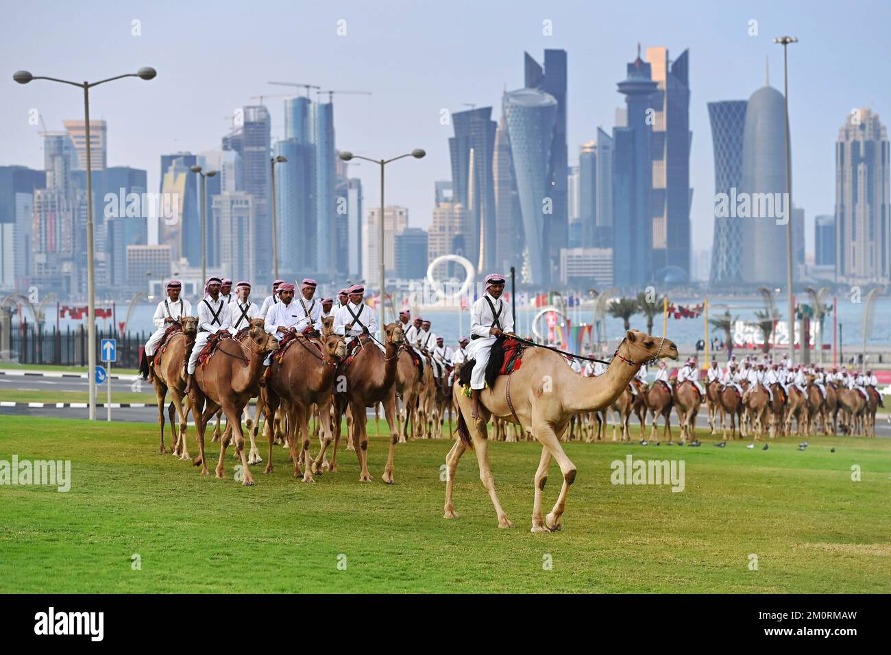 Impressioni da Doha/Qatar il 7th dicembre 2022. Le guardie di cammello montate sui cammelli girano davanti allo skyline di Doha fino alla sede del governo dell'Emiro dello Stato del Qatar. Uomini arabi, cammelli, cammelli. West Bay, alti edifici, Coppa del mondo di calcio 2022 in Qatar dal 20,11. - Dalle 18.12.2022 alle Foto Stock