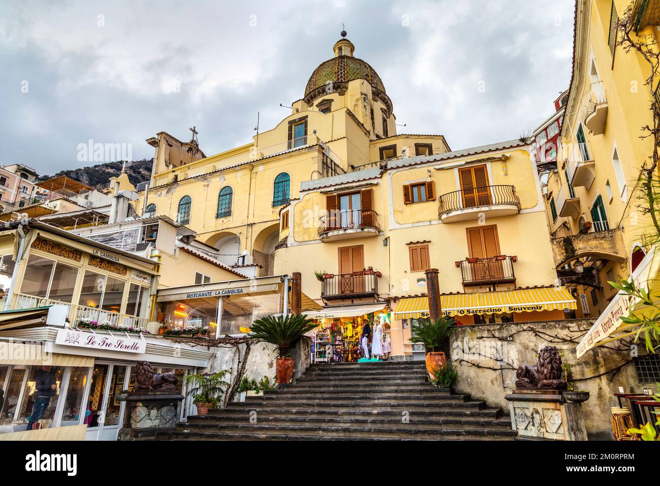 Case gialle sul lungomare di Positano e cupola della Chiesa di S. Maria Assunta, Positano, Campania, Italia Foto Stock