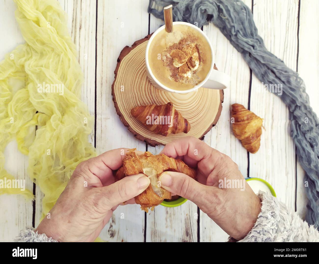Vista dall'alto di una persona che mangia un croissant e una tazza di cioccolata calda con panna montata Foto Stock Vista dall'alto di una persona che mangia un croissant e una tazza di cioccolata calda con panna montata Foto Stock