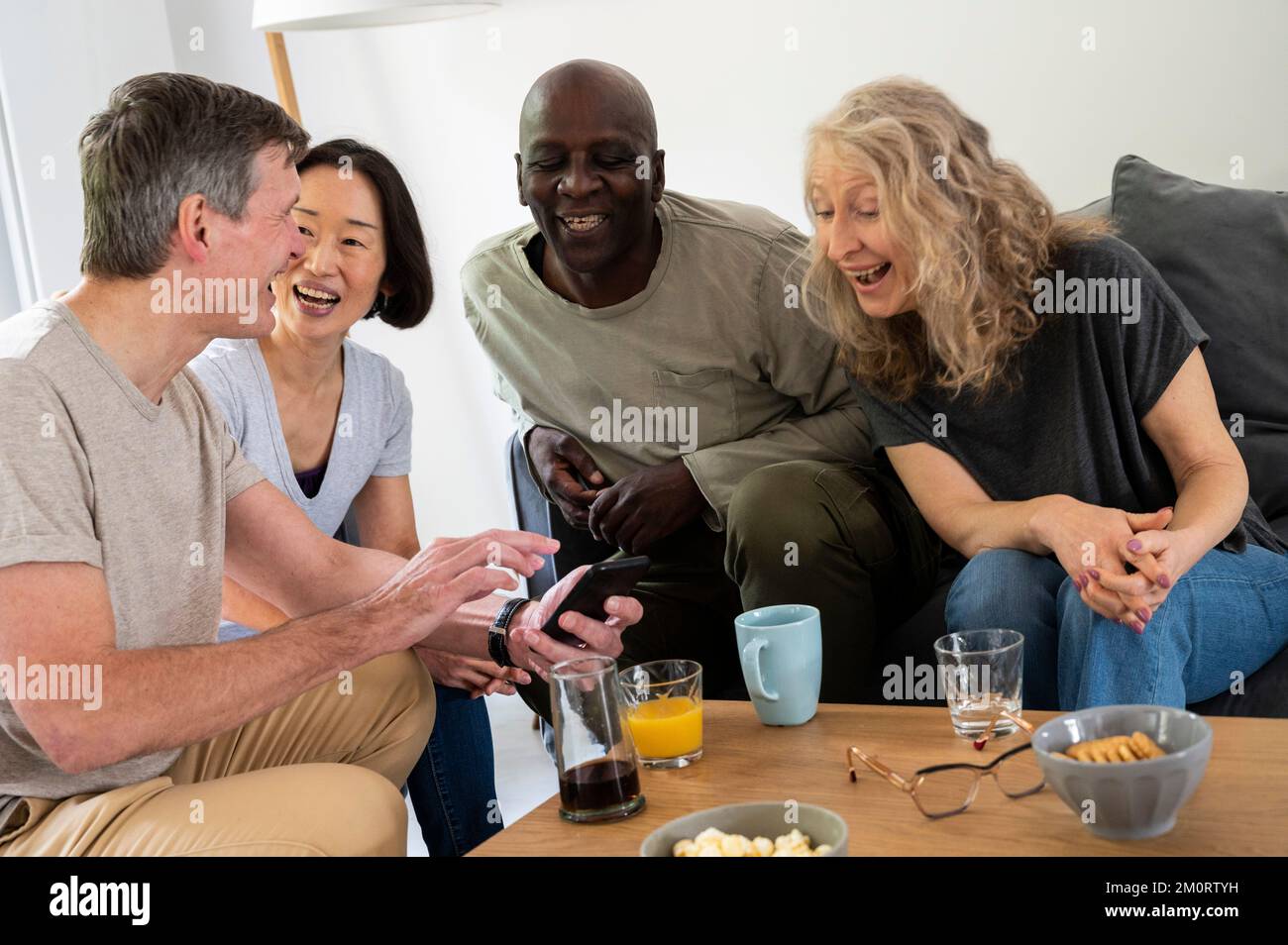 Gruppo di amici di mezza età che si divertono a casa Foto Stock