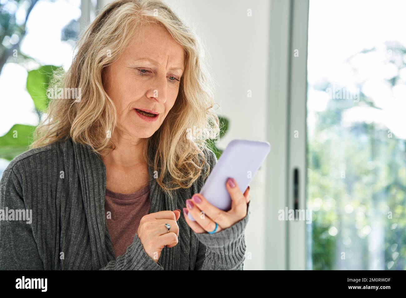 Donna anziana che controlla la posta in arrivo sullo smartphone Foto Stock