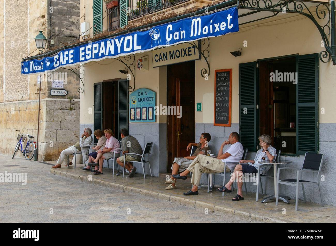 Le persone che si gustano bevande all'aperto al Cafe Can Moixet nella piazza del centro storico di Pollensa, Maiorca, Spagna. Foto Stock