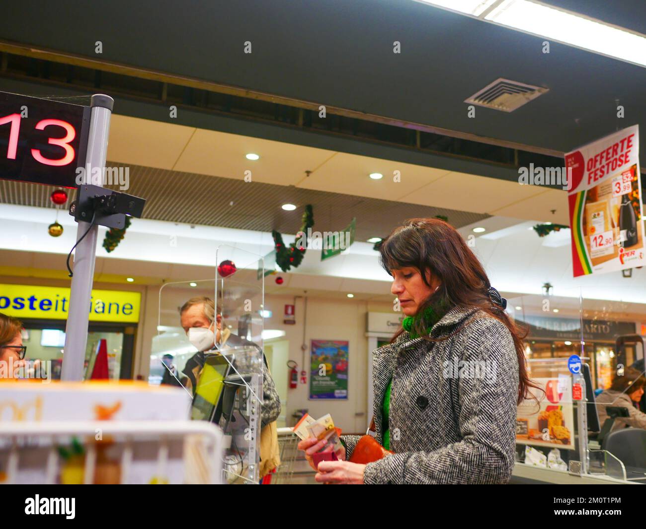 Cremona, Italia - Dicembre 2022 donna ispanica latina al cassiere in supermercato per la spesa Foto Stock