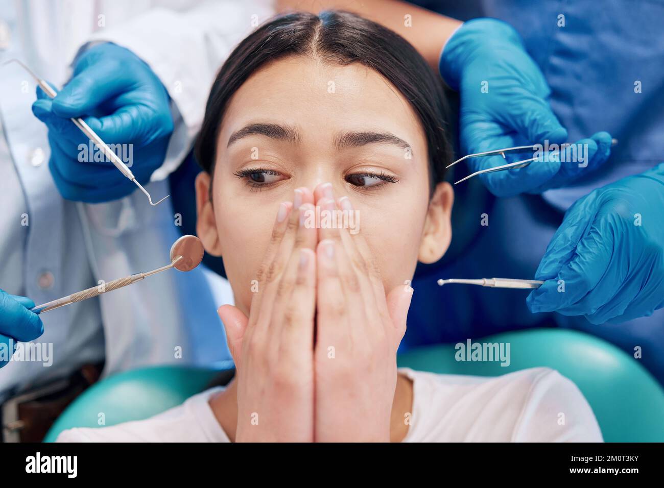 Una paura che si realizza per tutta la vita. una giovane donna che copre la bocca nella paura nel suo studio dentistico. Foto Stock
