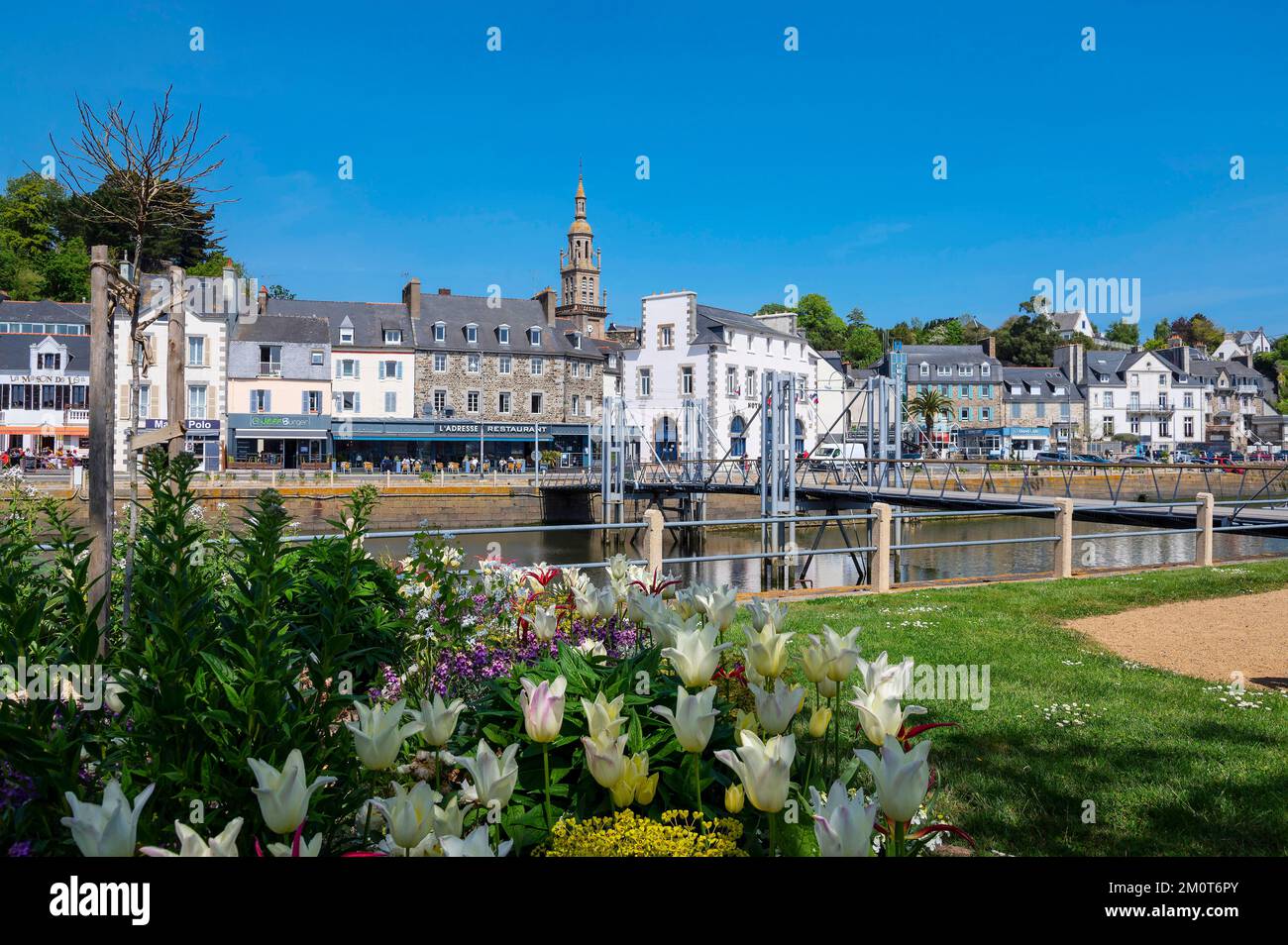 Francia, C?tes d'Armor, Binic-Etables sur Mer, composizioni floreali nel giardino del memoriale di guerra viale Foch sul porto e la passerella pedonale del IC. Dall'altro lato, Quai de Courcy e il campanile della chiesa di Notre Dame de Bon Voyage Foto Stock