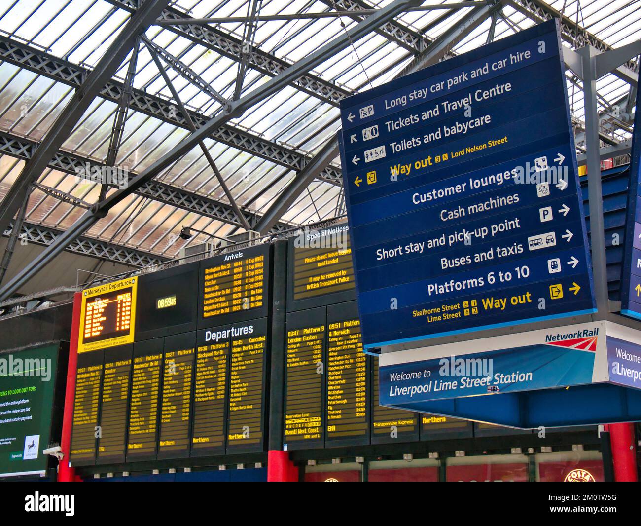 Alla stazione ferroviaria di Liverpool Lime Street, un cartello blu rettangolare con scritte bianche che mostrano le indicazioni per diversi luoghi. Informazioni sulla partenza del treno Foto Stock