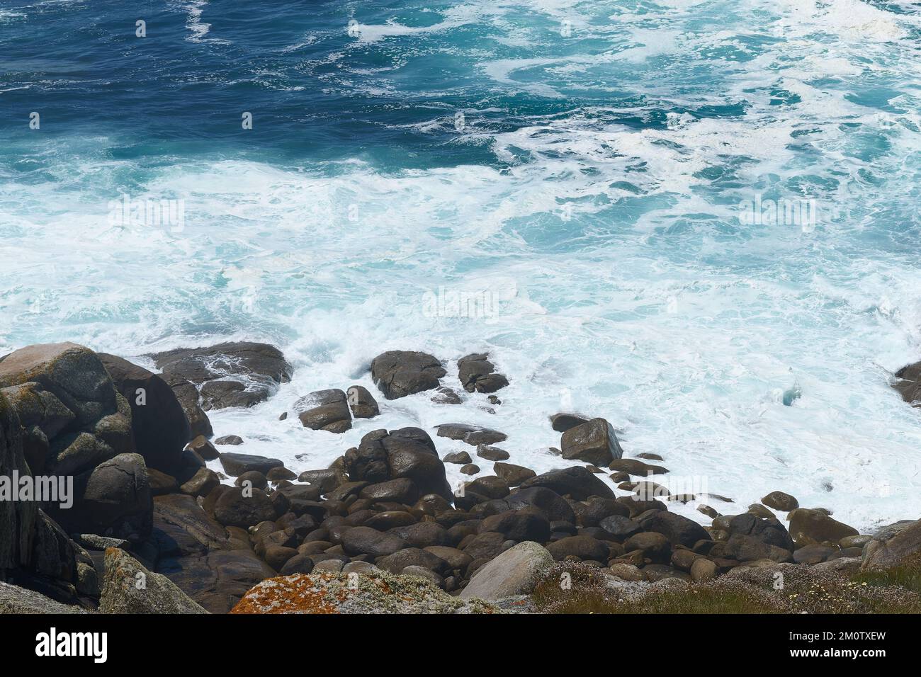 Un mare ondulato e la spiaggia ciottoli Foto Stock