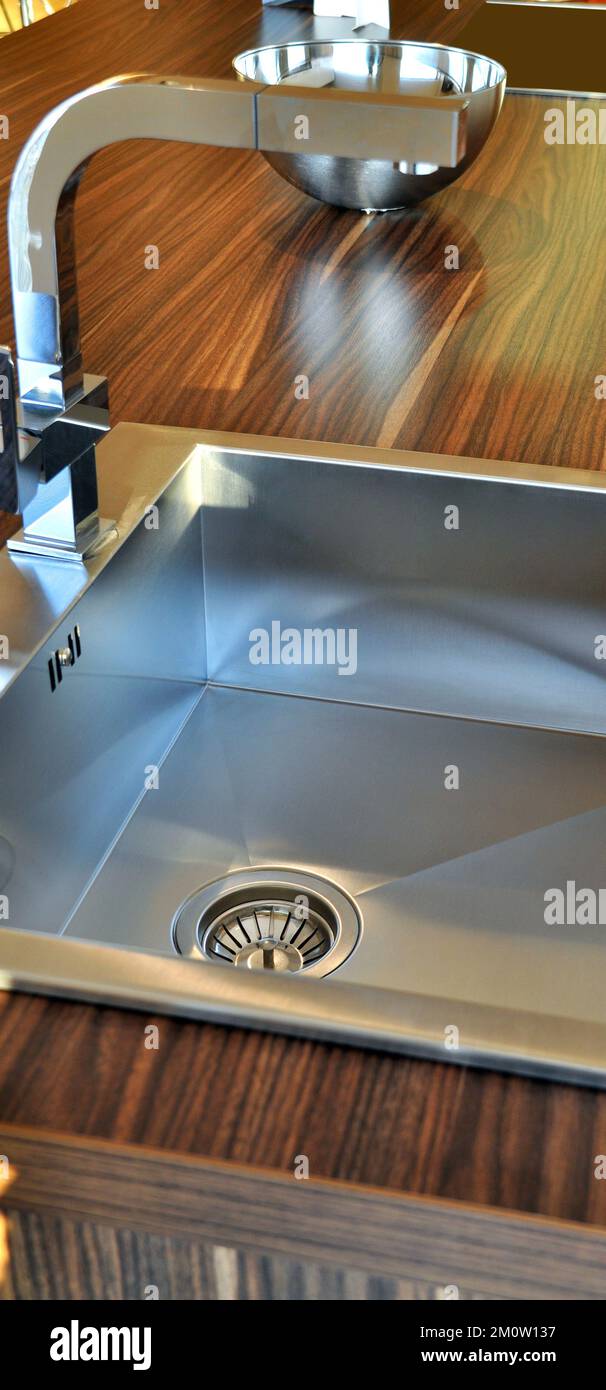 Interno di lussuosa cucina moderna e lavandino, rubinetto e scarico in acciaio inossidabile Foto Stock