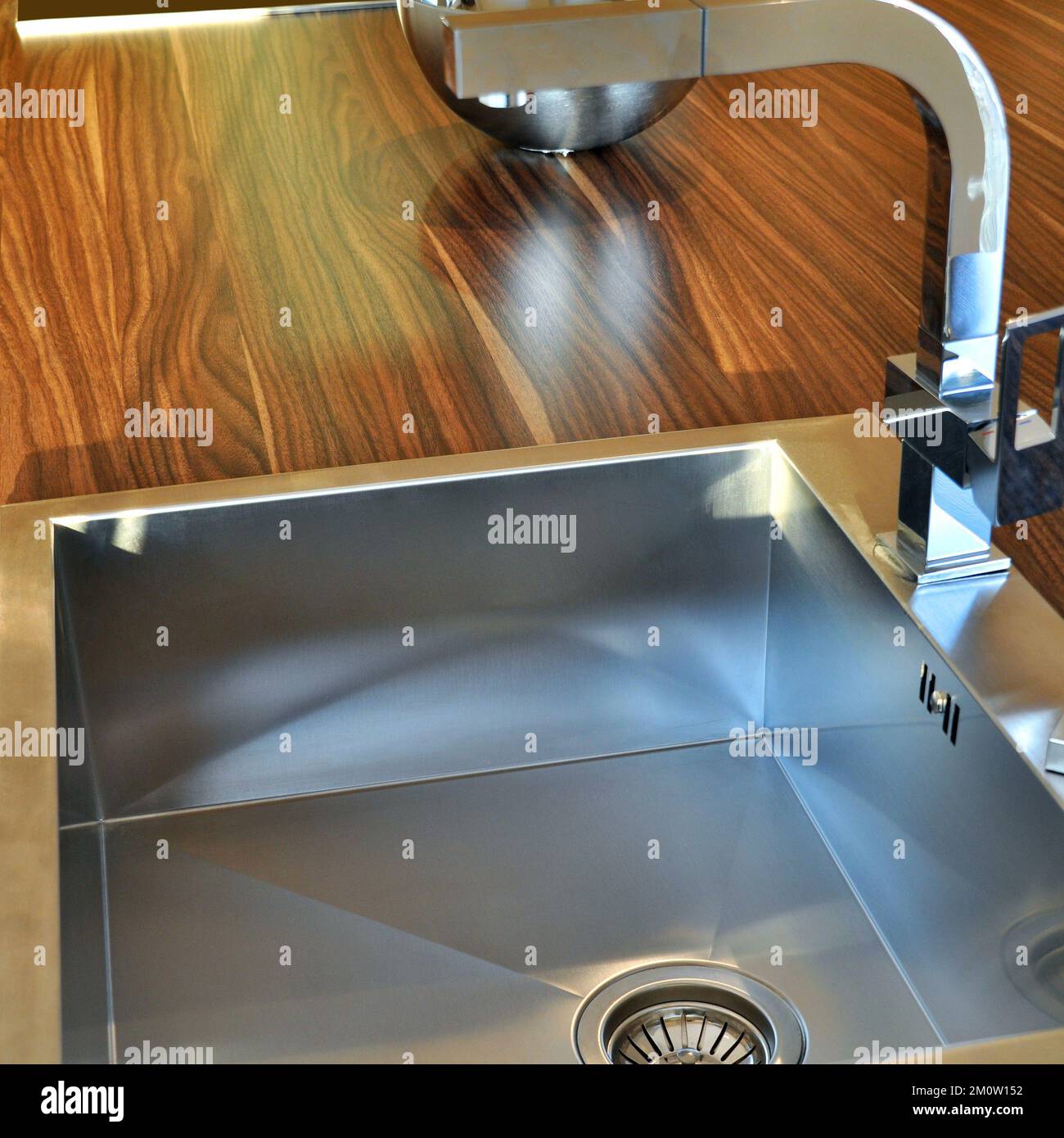 Interno di lussuosa cucina moderna e lavandino, rubinetto e scarico in acciaio inossidabile Foto Stock