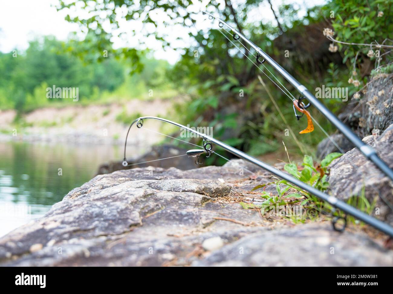 canne da pesca vicino al bordo dei fiumi spazio copia immagine di sfondo dell'hobby estivo attività ricreative Foto Stock