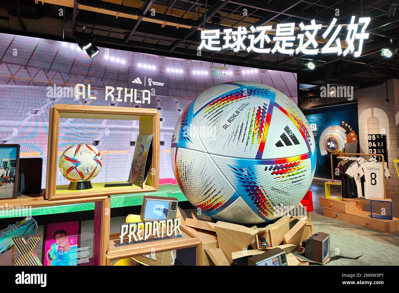 SHANGHAI, CINA - 8 DICEMBRE 2022 - la palla ufficiale della Coppa del mondo al RIHLA e un modello di calcio gigante sono esposti all'interno di un negozio Adidas a Shang Foto Stock