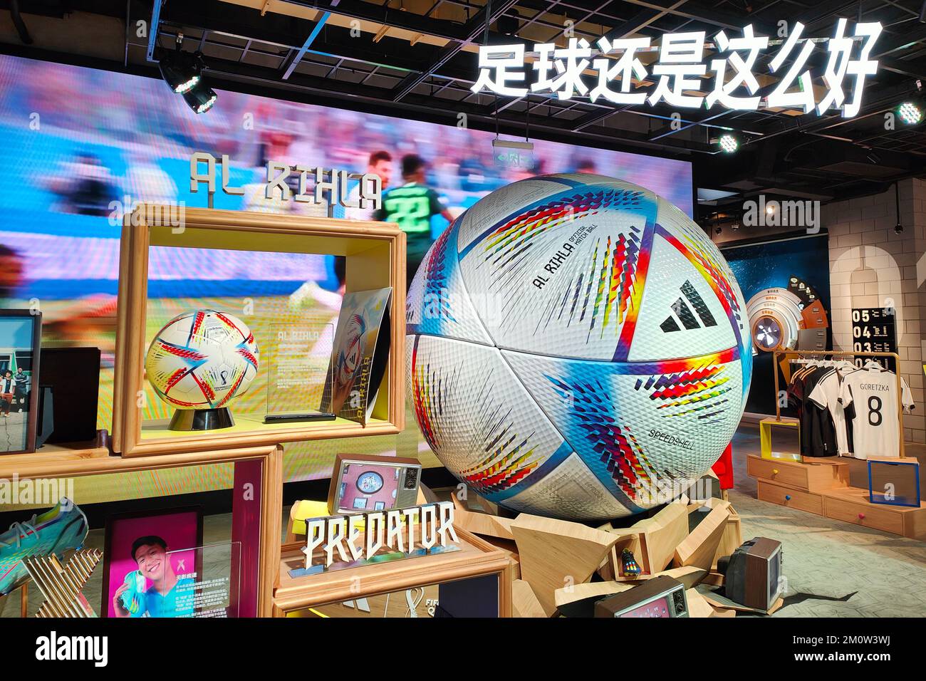 SHANGHAI, CINA - 8 DICEMBRE 2022 - la palla ufficiale della Coppa del mondo al RIHLA e un modello di calcio gigante sono esposti all'interno di un negozio Adidas a Shang Foto Stock