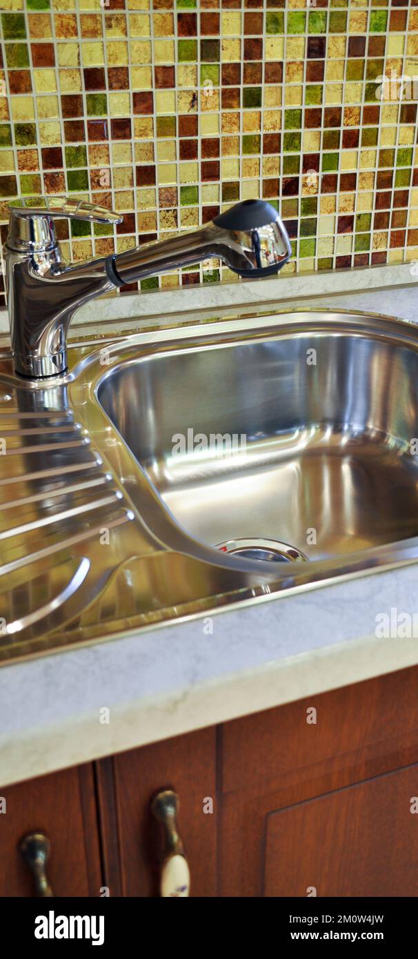 Interno di lussuosa cucina moderna e lavandino, rubinetto e scarico in acciaio inossidabile Foto Stock