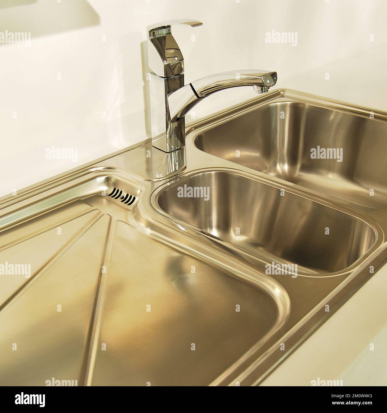 Interno di lussuosa cucina moderna e lavandino, rubinetto e scarico in acciaio inossidabile Foto Stock