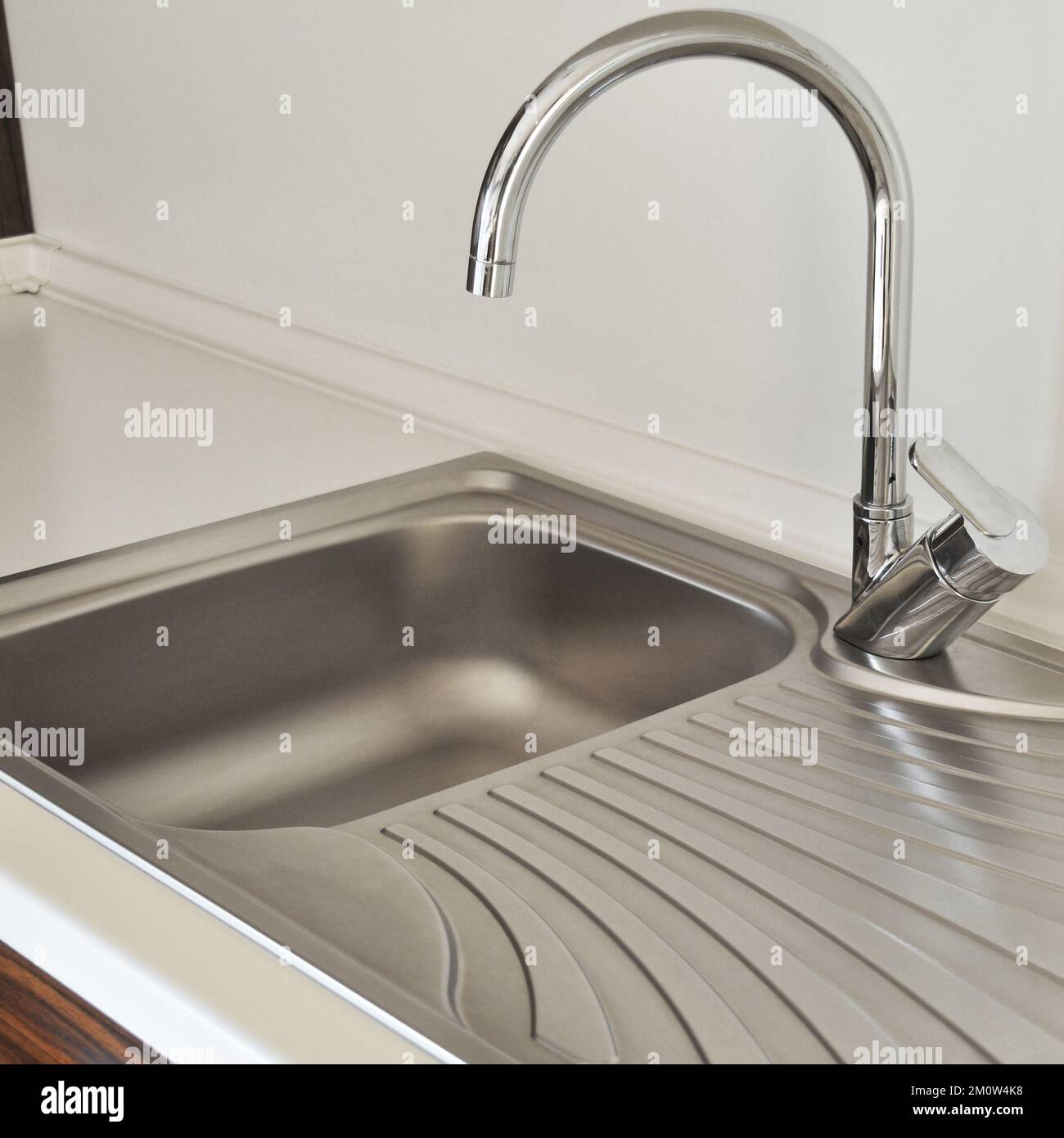 Interno di lussuosa cucina moderna e lavandino, rubinetto e scarico in acciaio inossidabile Foto Stock