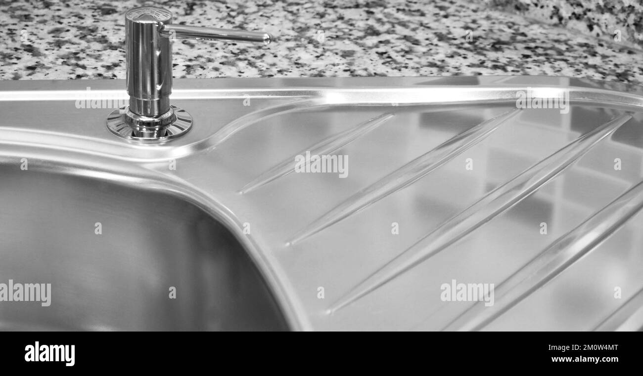 Interno di lussuosa cucina moderna e lavandino, rubinetto e scarico in acciaio inossidabile Foto Stock