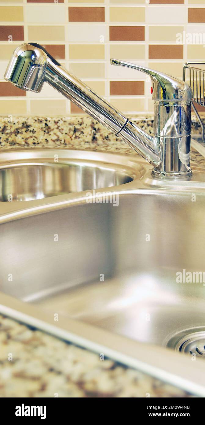 Interno di lussuosa cucina moderna e lavandino, rubinetto e scarico in acciaio inossidabile Foto Stock