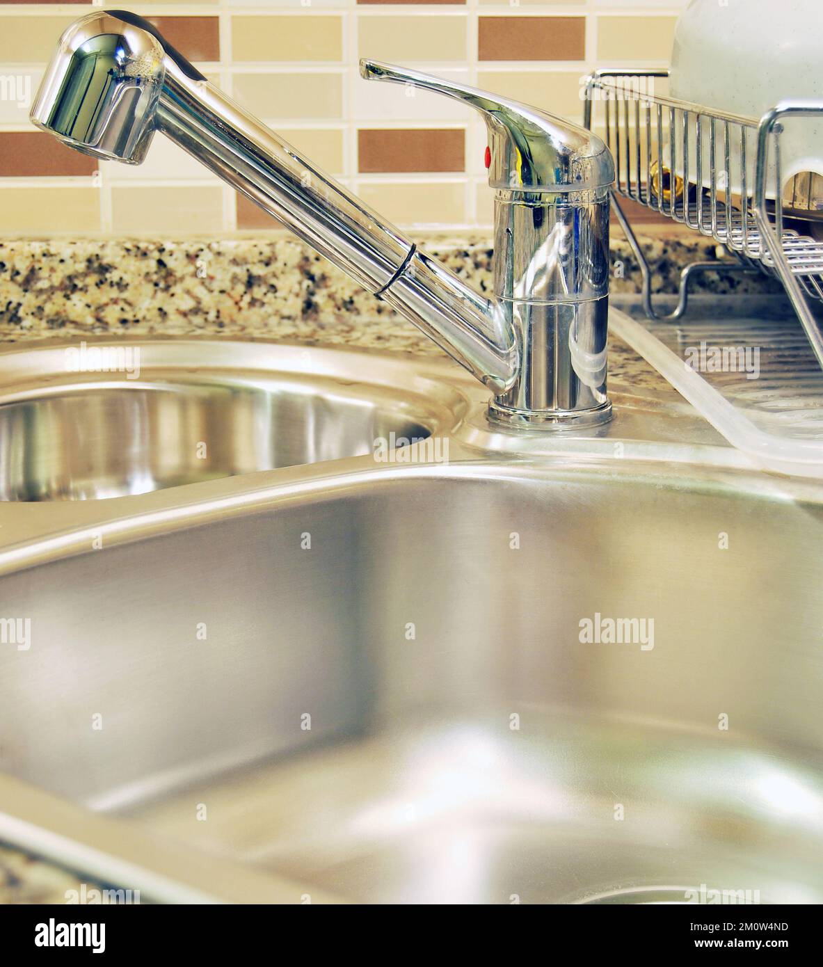 Interno di lussuosa cucina moderna e lavandino, rubinetto e scarico in acciaio inossidabile Foto Stock
