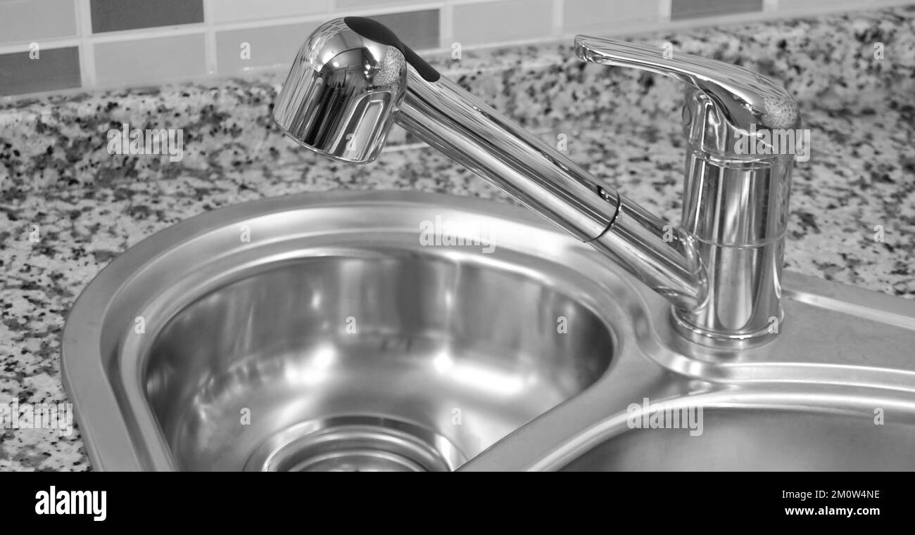 Interno di lussuosa cucina moderna e lavandino, rubinetto e scarico in acciaio inossidabile Foto Stock