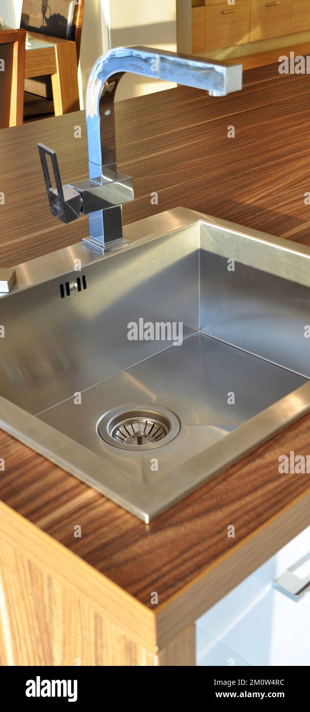 Interno di lussuosa cucina moderna e lavandino, rubinetto e scarico in acciaio inossidabile Foto Stock