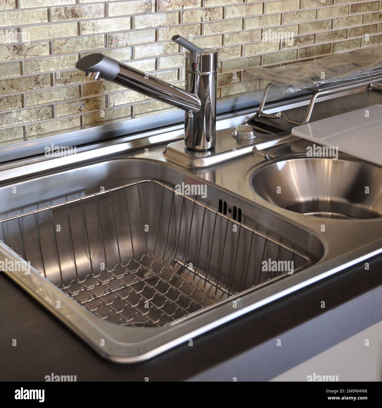 Interno di lussuosa cucina moderna e lavandino, rubinetto e scarico in acciaio inossidabile Foto Stock